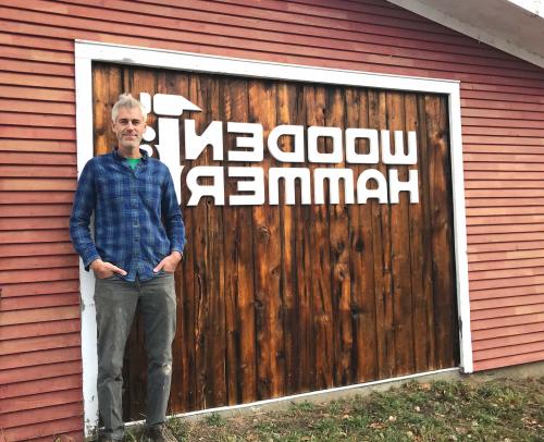 Ben Rafael standing in front of the Wooden Hammer sign